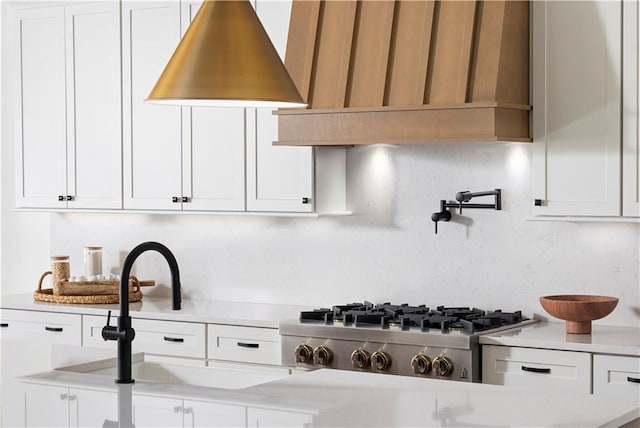 kitchen featuring a sink, light countertops, stainless steel gas cooktop, and white cabinetry