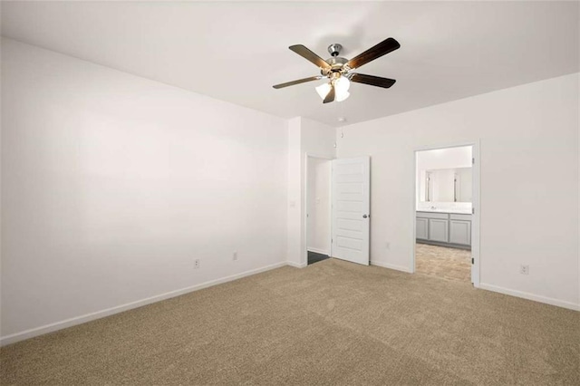 unfurnished bedroom featuring connected bathroom, light colored carpet, and ceiling fan