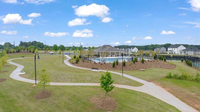 surrounding community with a yard and a swimming pool