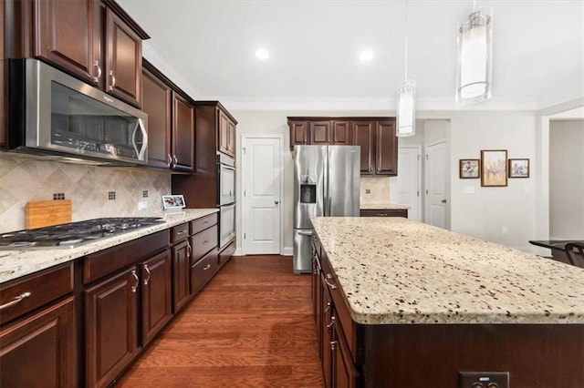 337 Spotted Ridge Cir, Woodstock, GA 30188 - kitchen featuring appliances with stainless steel finishes, a kitchen island, light stone counters, crown molding, and recessed lighting