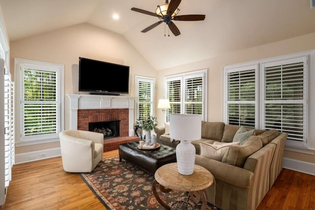 living room featuring vaulted ceiling, wood finished floors, a ceiling fan, plenty of natural light, and baseboards