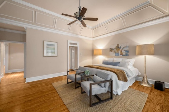 bedroom with baseboards, wood finished floors, crown molding, and a ceiling fan