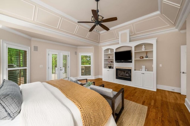 bedroom with access to exterior, ornamental molding, french doors, a fireplace, and wood finished floors