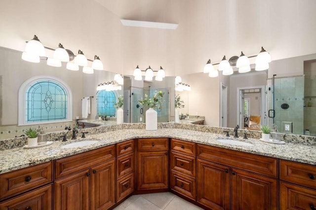 bathroom featuring a stall shower, tile patterned floors, and double vanity