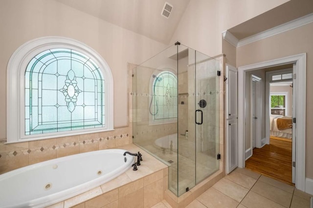 ensuite bathroom featuring a tub with jets, a shower stall, tile patterned flooring, and crown molding