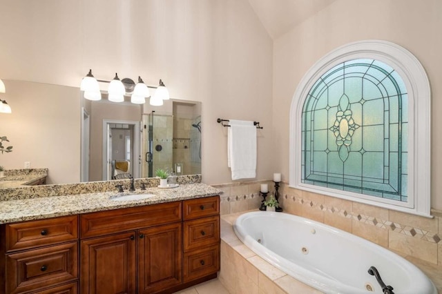 full bathroom with a shower stall, vaulted ceiling, a whirlpool tub, and vanity