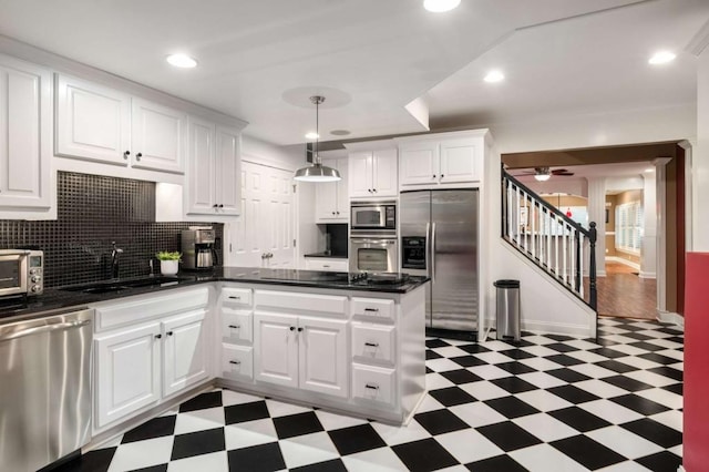 kitchen featuring stainless steel appliances, tile patterned floors, a sink, dark countertops, and recessed lighting