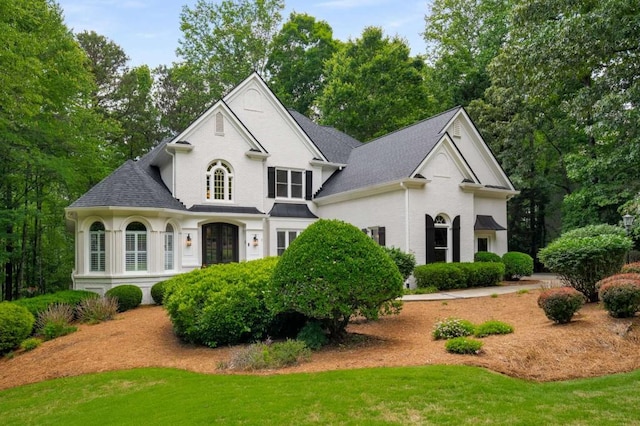 view of front of property featuring a front yard and a shingled roof
