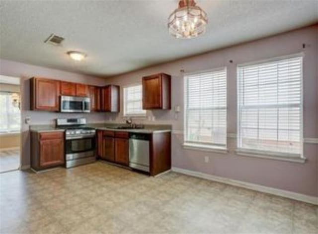 6684 Crane Ave, Fairburn, GA 30213 - kitchen featuring appliances with stainless steel finishes, baseboards, healthy amount of natural light, and light countertops