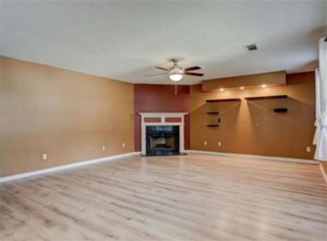 6684 Crane Ave, Fairburn, GA 30213 - unfurnished living room featuring a ceiling fan, wood finished floors, a fireplace with flush hearth, and baseboards