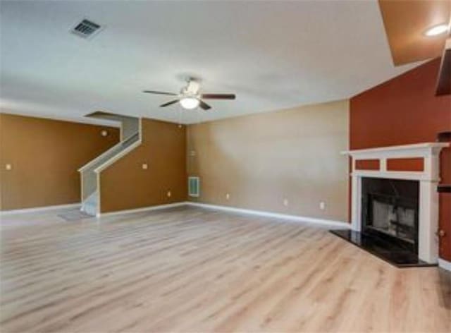 6684 Crane Ave, Fairburn, GA 30213 - unfurnished living room with a ceiling fan, wood finished floors, baseboards, stairway, and a fireplace with raised hearth