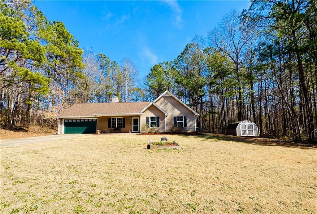 33 Bo Xing, Temple, GA 30179 - ranch-style home with a garage, a chimney, a front yard, and concrete driveway