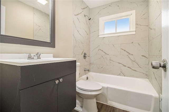 full bathroom with hardwood / wood-style flooring, toilet, vanity, and tiled shower / bath