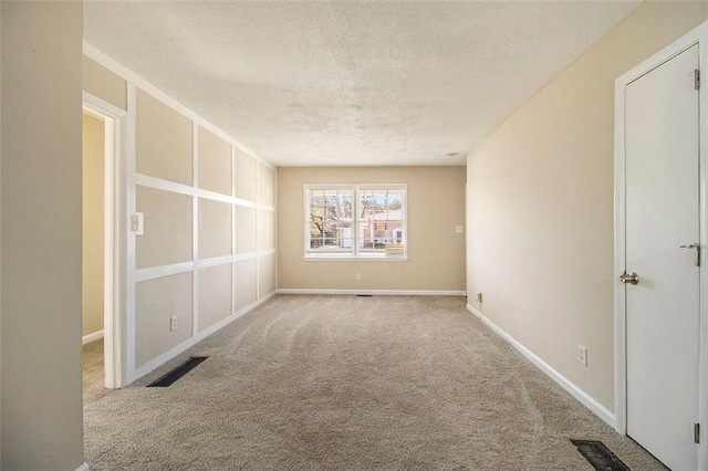 carpeted spare room with a textured ceiling