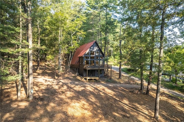 rear view of property featuring a wooden deck