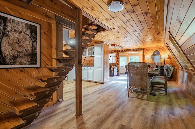 dining space with wood finished floors, wood ceiling, wood walls, and vaulted ceiling