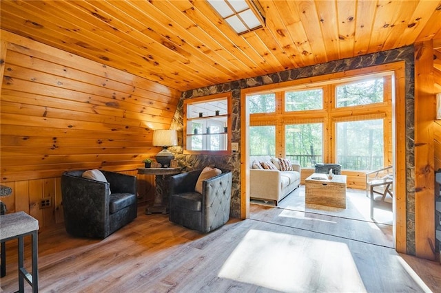 living room with wood finished floors, wooden walls, wood ceiling, and vaulted ceiling