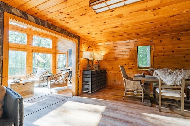 interior space with wooden ceiling, wooden walls, wood finished floors, and vaulted ceiling