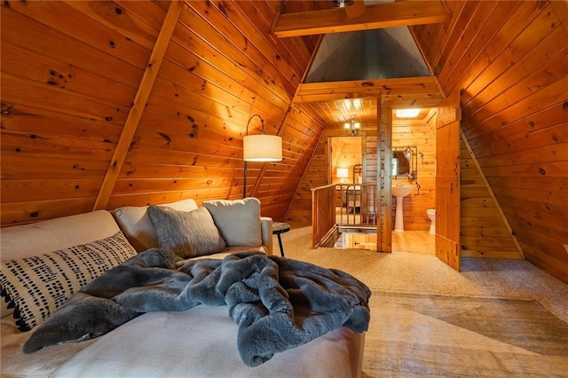 bedroom featuring lofted ceiling with beams, wooden walls, and carpet