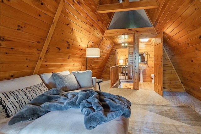 bedroom with wood ceiling, wood walls, vaulted ceiling with beams, and carpet floors