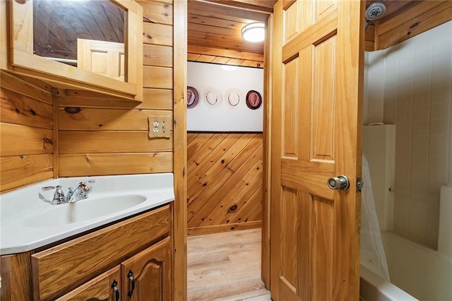 full bathroom featuring vanity, wood finished floors, shower / bath combo, wood walls, and wooden ceiling