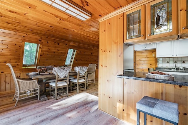 dining room featuring wood finished floors, wooden walls, and wood ceiling