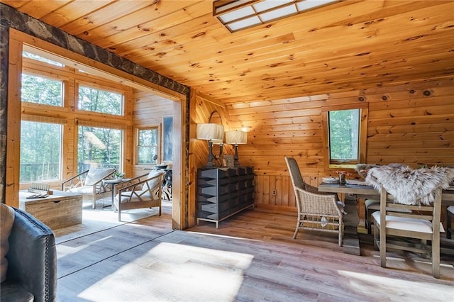 interior space with lofted ceiling, wood ceiling, wood finished floors, and wood walls