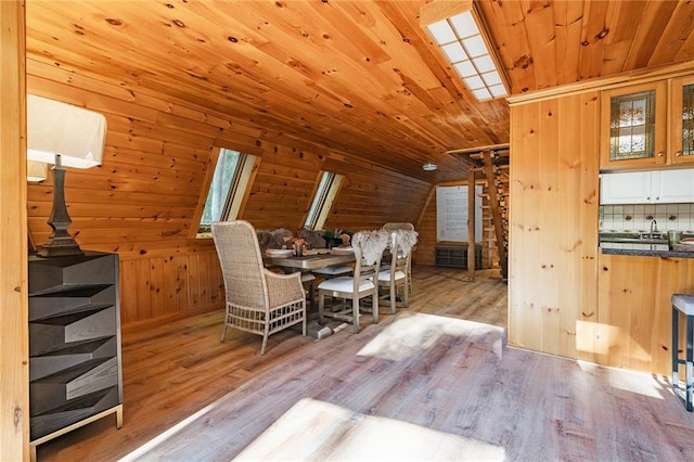 dining room with wood finished floors, lofted ceiling, wooden ceiling, and wood walls