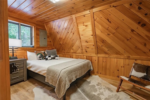 bedroom with electric panel, light wood-type flooring, wood ceiling, and wood walls