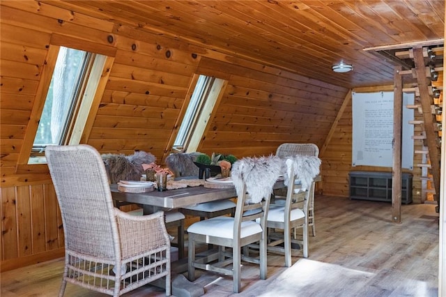 dining room featuring lofted ceiling, wood finished floors, wood ceiling, and wood walls