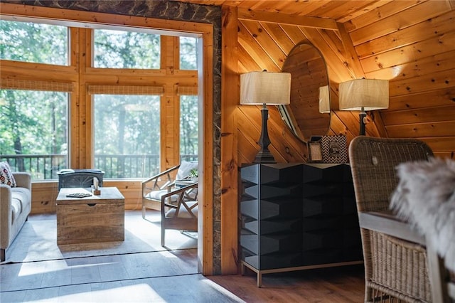 living room featuring wood walls, wooden ceiling, and wood finished floors