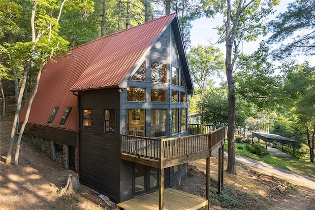 back of house featuring a deck and metal roof