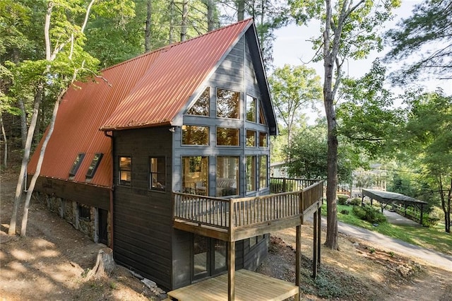 rear view of house featuring metal roof and a wooden deck