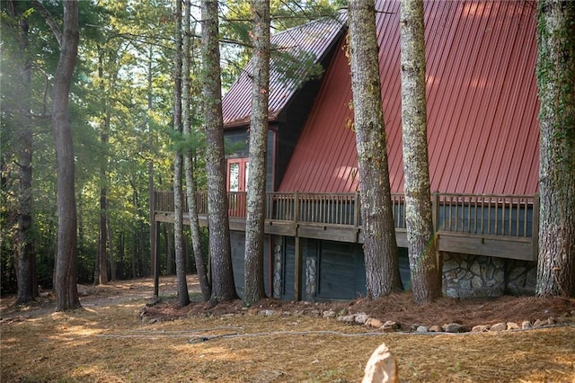 view of side of home featuring metal roof and a deck