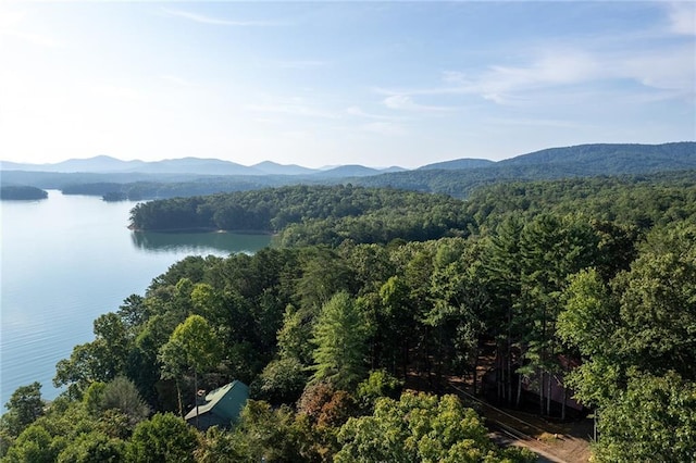 aerial view with a wooded view and a water and mountain view