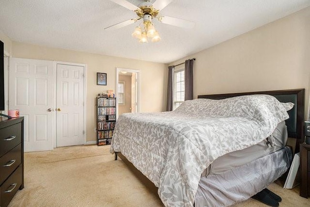 carpeted bedroom featuring ceiling fan and a closet