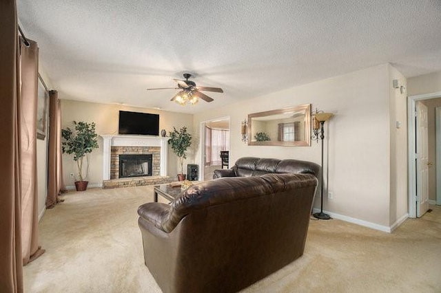 carpeted living room with ceiling fan, a stone fireplace, and a textured ceiling