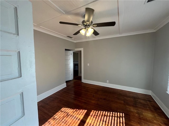 empty room with ceiling fan, wood finished floors, visible vents, baseboards, and ornamental molding
