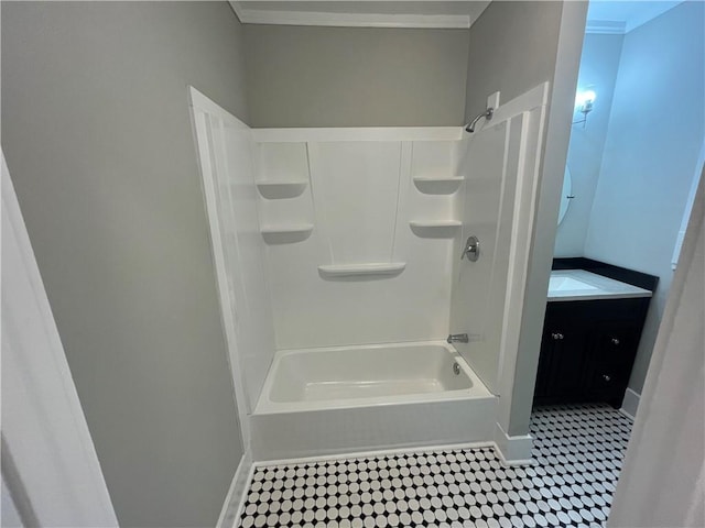 bathroom featuring baseboards, tile patterned flooring, crown molding, vanity, and shower / washtub combination