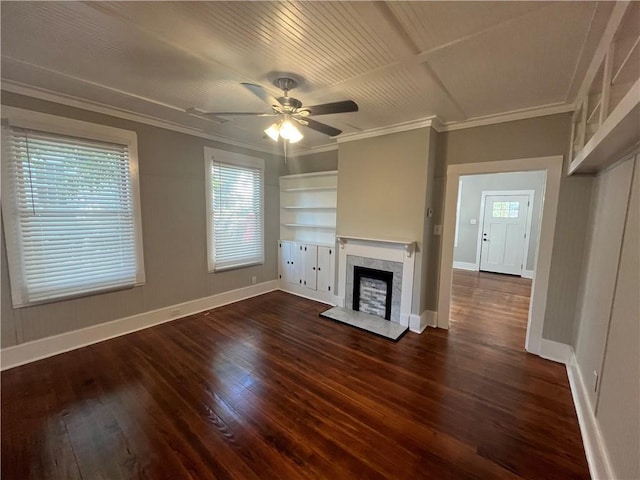 unfurnished living room featuring a fireplace with raised hearth, dark wood-style flooring, baseboards, and crown molding