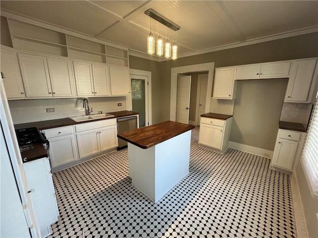 kitchen featuring dishwasher, butcher block countertops, a sink, crown molding, and backsplash