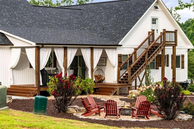 rear view of property with a wooden deck and an outdoor fire pit