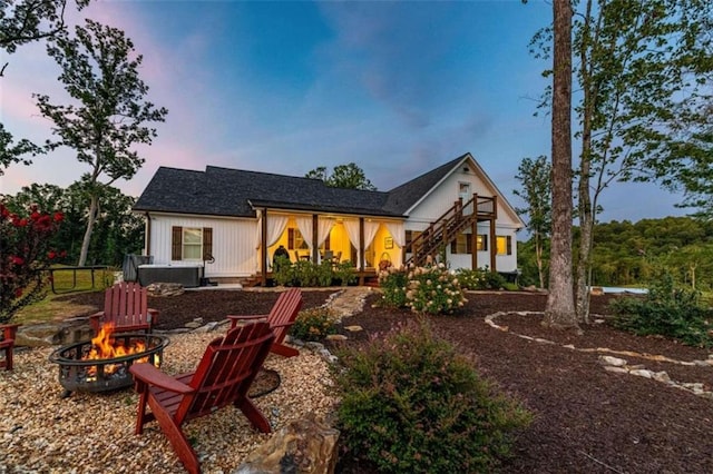 back house at dusk featuring a patio area and an outdoor fire pit