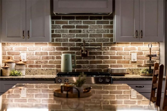 interior details featuring gray cabinets, dark stone countertops, and stainless steel range oven