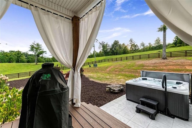 exterior space with a rural view and a hot tub