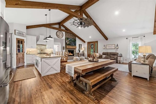 dining space with beam ceiling, high vaulted ceiling, wood-type flooring, and ceiling fan