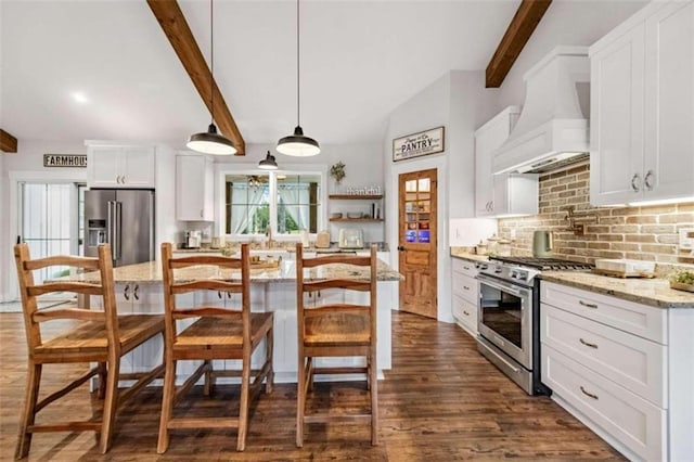 kitchen with white cabinets, light stone counters, decorative light fixtures, and premium appliances