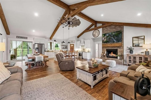 living room with high vaulted ceiling, a fireplace, ceiling fan, beamed ceiling, and hardwood / wood-style flooring