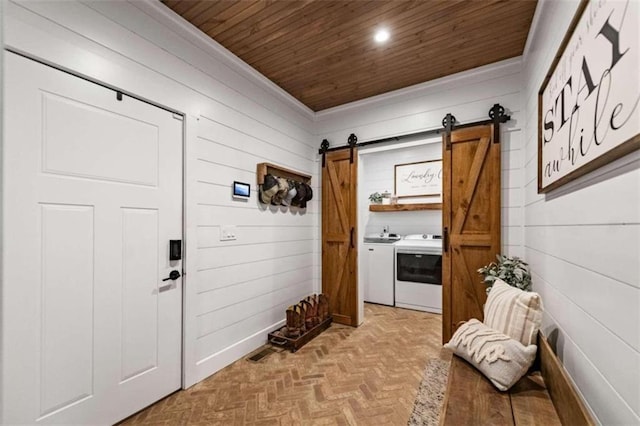 mudroom with light parquet flooring, wooden ceiling, separate washer and dryer, and wooden walls