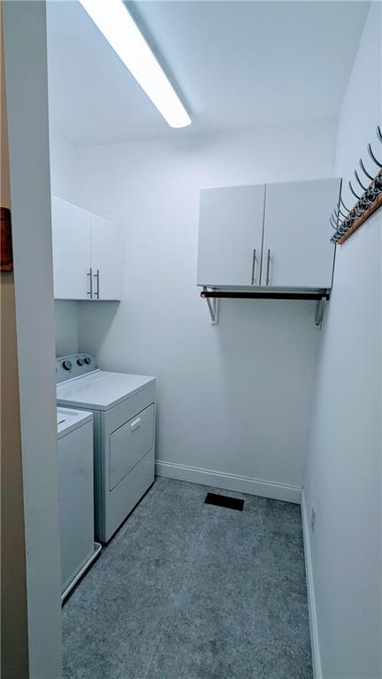 laundry area with dark carpet, cabinets, and separate washer and dryer